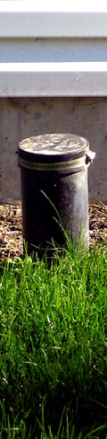 This is the cylindrical black thing that sticks out of the ground next to the apartment building in front of us. It's sunny outside, so everything is bright and cheery, even the black thing.