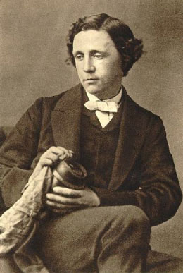 A portrait of Lewis Carroll seated, wearing a suit, holding an object, and looking down and to the left.