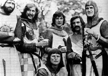 Photograph of the members of Monty Python dressed in their 'Holy Grail' costumes drinking out of paper cups.